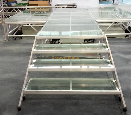 Escenario de cristal sobre la piscina con escaleras de cristal transparente